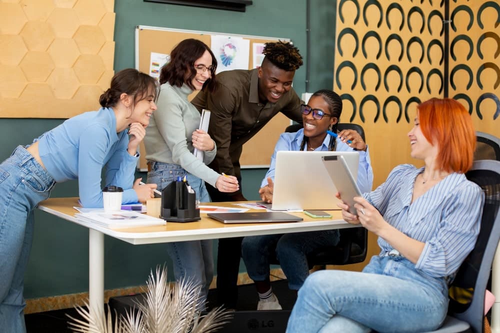 A diverse group of employees collaborating and working together in a modern office environment, embracing diversity and inclusivity at work.